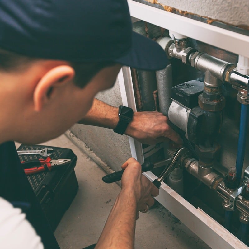 The man is installing the heater system in the house